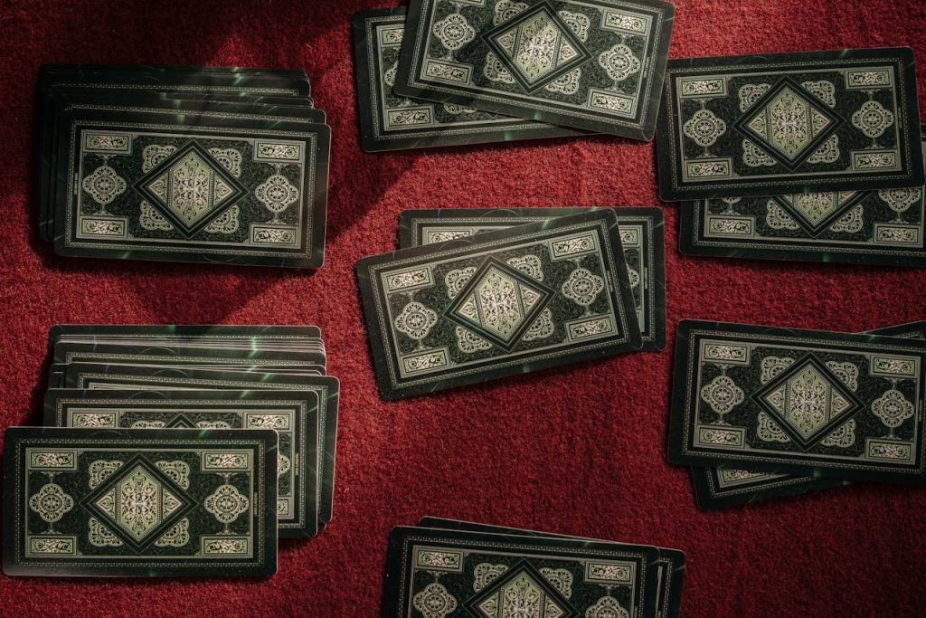 Top view of intricate playing cards on a rich red texture, perfect for game and mystery themes.